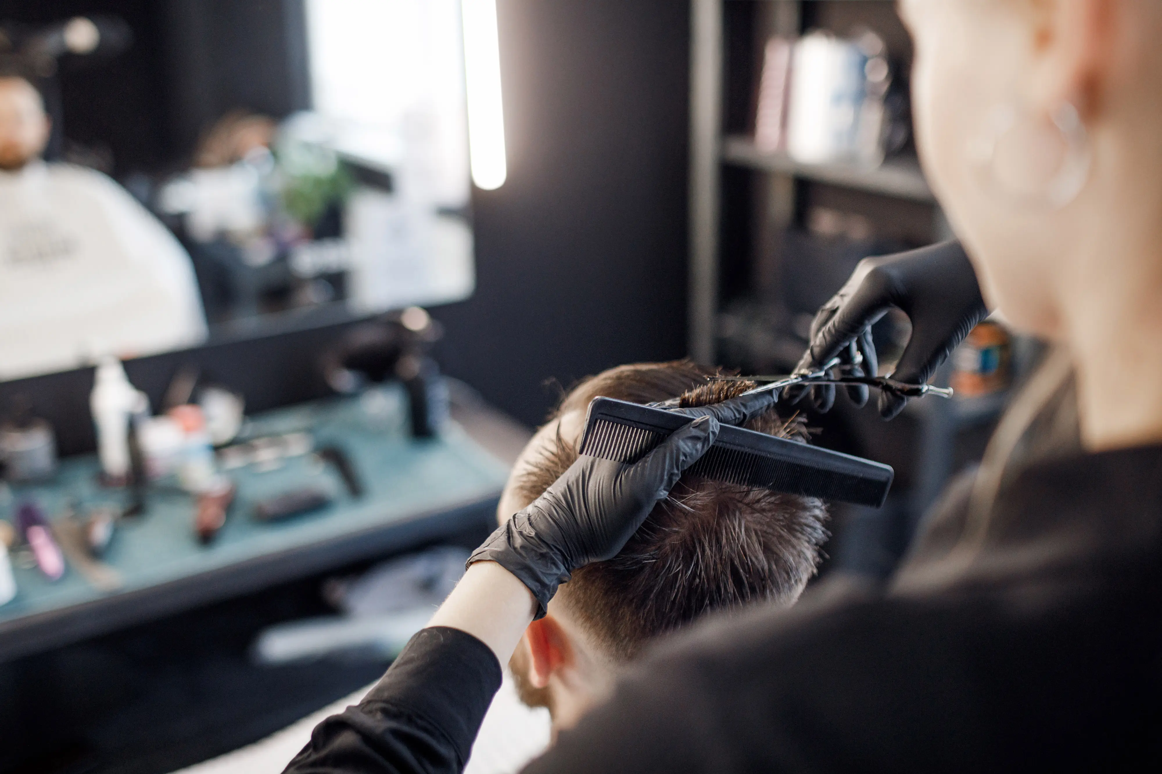 Barbeiro cortando cabelo em uma barbearia